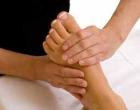Junger Fussmasseur bietet seinen Sevice der Geschäftsfrau/ Dame